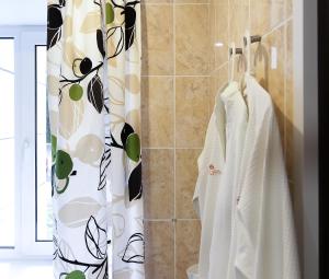 łazienka z zasłoną prysznicową i ręcznikami w obiekcie Hotel "Otel flowerS" w mieście Perm