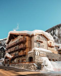 a large building with snow on top of it at Hôtel Avancher in Val dʼIsère