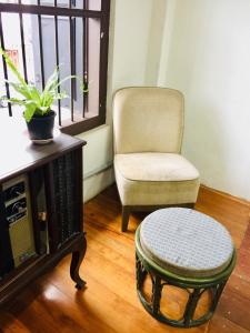 a chair and a ottoman in a living room at Phuket Sunny Hostel in Phuket Town