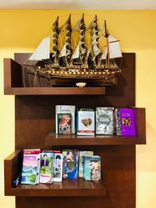 a shelf with a model of a ship and books at Phuket Sunny Hostel in Phuket Town