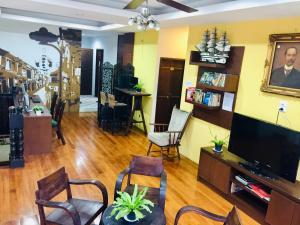 a living room with a flat screen tv and chairs at Phuket Sunny Hostel in Phuket Town