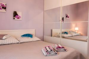 グダニスクにあるLuxury Apartment Bursztynowaのベッド2台、鏡、タオルが備わる客室です。