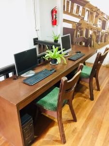 a wooden desk with two computers on top of it at Phuket Sunny Hostel in Phuket Town