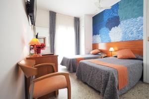 una habitación de hotel con 2 camas y una gran pintura en la pared en Hotel Montserrat, en Sitges