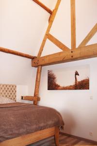 Chaumont-GistouxにあるWengé Lodgeのベッドルーム1室(ベッド1台付)が備わります。壁にキリンの写真が飾られています。