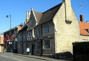 un viejo edificio de ladrillo al lado de una calle en Marquis of Granby, en Sleaford