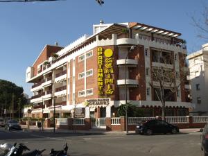 a building with a yellow sign on the side of it at Apartaments Geminis in Cambrils