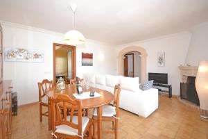 ein Wohnzimmer mit einem Tisch und einem weißen Sofa in der Unterkunft House Barca in Alcúdia