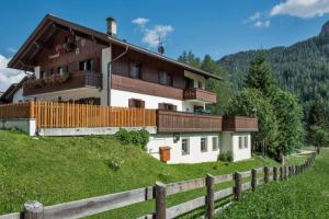 una casa en una colina con una valla en Apartments Fiordalisi, en Colfosco