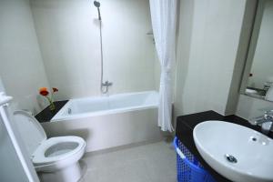 a bathroom with a toilet and a sink and a bath tub at Granda Legend Apartment in Hanoi