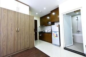 a kitchen with wooden cabinets and a refrigerator at Granda Legend Apartment in Hanoi +4 photos