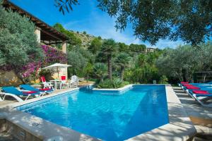 een zwembad met ligstoelen naast een huis bij Owl Booking Villa El Vila - Amazing Views in Port de Pollença