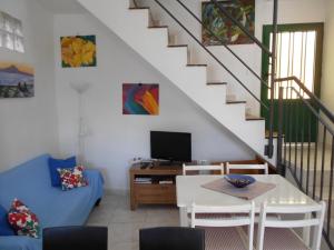 a living room with a table and a tv at Casita Canaria in Santa Cruz de Tenerife
