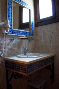 uma casa de banho com um lavatório e um espelho em Petrini Gonia em Livadero