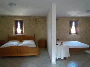 a bedroom with a bed and a table and two windows at Burg Katzenstein in Katzenstein