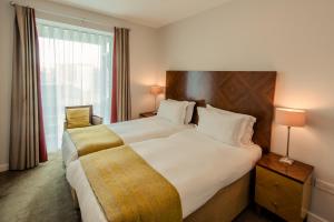 a hotel room with a large bed and a window at PREMIER SUITES Dublin, Sandyford in Sandyford