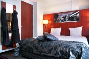 a bedroom with a large bed with a red headboard at Fletcher Hotel-Restaurant De Kempen in Reusel