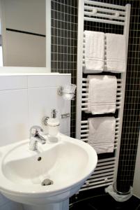 - Baño con lavabo blanco y toallas en Fletcher Hotel-Restaurant De Kempen en Reusel