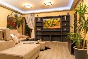 a living room with a couch and a tv at Blanche Cliff Apartments in Sveti Stefan