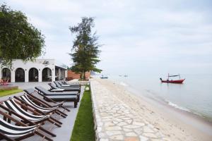 a row of chaise lounge chairs on the beach at Siambeach Resort in Cha Am