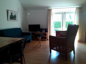 ein Wohnzimmer mit einem blauen Sofa und Stühlen in der Unterkunft Bed & Breakfast Uiterburen in Zuidbroek