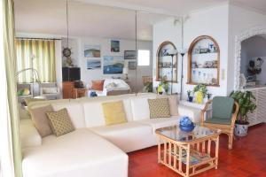 uma sala de estar com um sofá branco e uma mesa em Casa do Mar em São Roque