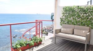einen Balkon mit einer Bank und Meerblick in der Unterkunft Casa do Mar in São Roque