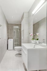 a white bathroom with a toilet and a sink at Forenom Serviced Apartments Oslo Vika in Oslo