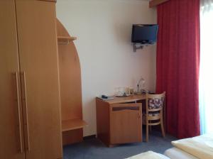 ein Schlafzimmer mit einem kleinen Schreibtisch, einem Bett und einem roten Vorhang in der Unterkunft Leonsteinerhof in Leonstein