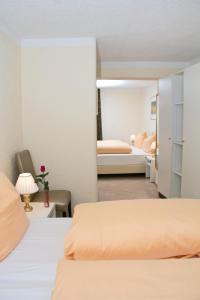 a bedroom with two beds and a room with two beds at Hotel Albergo Mamma Rosa in Wunsiedel