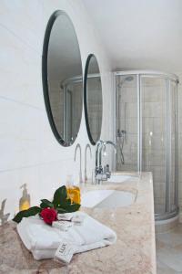 a bathroom with a sink and two mirrors at Hotel Albergo Mamma Rosa in Wunsiedel