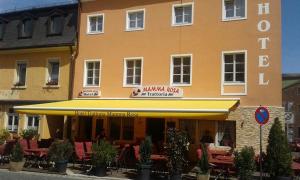 a building with a restaurant with tables and chairs at Hotel Albergo Mamma Rosa in Wunsiedel