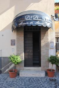 una entrada a la tienda con dos macetas delante de ella en A CASA DI ANNA, en Cerveteri