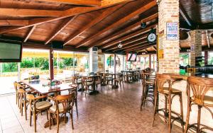 un restaurante con mesas y sillas y un bar en Yiannis Manos Hotel Resort, en Malia