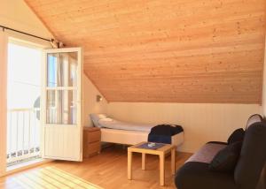 a room with a bed and a couch and a window at Hindrum Fjordsenter in Vannvikan