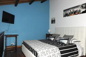 1 dormitorio con 1 cama con pared azul en A CASA DI ANNA, en Cerveteri
