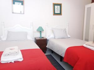 two beds in a room with a red blanket at Apartamento Esperanto in Las Lagunas