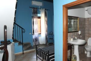 baño con paredes azules, lavabo y escalera en A CASA DI ANNA, en Cerveteri