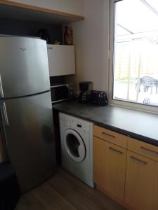a kitchen with a refrigerator and a washing machine at gîte Théalys- proche Puy du Fou in La Petite-Boissière +6 photos