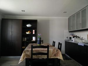 a kitchen with a table with chairs and a kitchen with a counter at Casa da Avó Arminda in Cantanhede