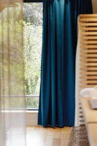 un rideau bleu devant une fenêtre dans l'établissement Hôtel & Restaurant Le Pré, à Durtol