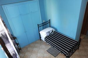 Habitación azul pequeña con cama y armario en A CASA DI ANNA, en Cerveteri