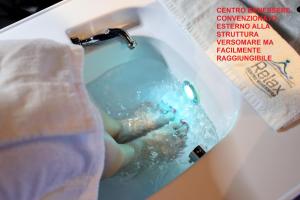 a person is washing their hands in a sink at Versomare in Polignano a Mare
