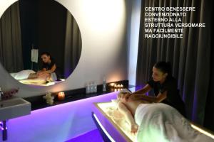a man getting a massage in a room with two mirrors at Versomare in Polignano a Mare
