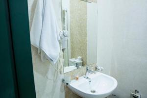 een badkamer met een wastafel en een spiegel bij City Walls Hotel in Baku