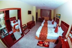 a hotel room with two beds and a mirror at Tiffany Diamond Hotels LTD - Makunganya in Dar es Salaam