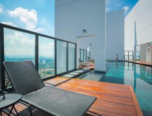 einen Balkon mit Pool und Stühlen auf einem Gebäude in der Unterkunft THE HUB SS2 in Petaling Jaya