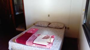 a small bedroom with two beds in a room at Pousada Arco Íris in Tabapira