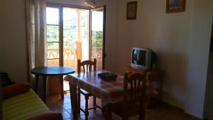 - un salon avec une table et une télévision dans l'établissement Apartamentos Las Colinas, à Vélez-Málaga