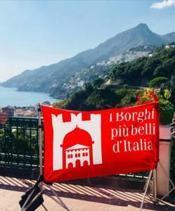 a red and white flag sitting on top of a balcony at La Califfa in Vietri sul Mare